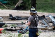 Un bombero toma un descanso con vistas a las secuelas en el GoodWater RV Park en Georgetown, donde la crecida del río San Gabriel ha producido peligrosas inundaciones