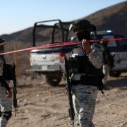 Miembros de la Guardia Nacional de México hacen guardia en la escena de un crimen.