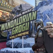 Un cosplayer disfrazado de mandaloriano junto a Grogu en el estreno mundial de
