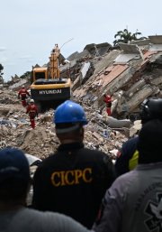 Voluntarios y paramédicos permanecen inmóviles mientras los rescatistas realizan pruebas acústicas en busca de sobrevivientes