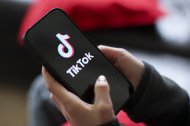 Una niña sostiene un iPhone 16 con el logotipo de la aplicación TikTok/ Jan Woitas