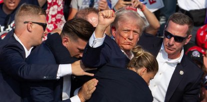 El candidato republicano estadounidense Donald Trump es visto con sangre en la cara rodeado de agentes del servicio secreto mientras es sacado del escenario en un acto 
de campaña tras un intento de asesinato en Butler Farm Show Inc. en Butler, Pensilvania, el 13 de julio de 2024.