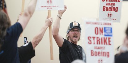 Union members react as Aerospace Machinists District 751 President Jon Holden (out of frame) announces that union members rejected a proposed Boeing contract and will go on strike, following voting results at their union hall in Seattle, Washington, on September 12, 2024. - Boeing workers in the Seattle region overwhelmingly voted to strike on September 12, rejecting a contract the embattled aviation giant characterized as a boon for staff given the company's stressed financial condition. (Photo by Jason Redmond / AFP)