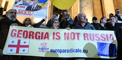 La oposición europeísta organiza una manifestación en Georgia en la que desfilan con banderas de Ucrania, de la UE y una pancarta en contra del acercamiento a Rusia.