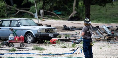 Un bombero toma un descanso con vistas a las secuelas en el GoodWater RV Park en Georgetown, donde la crecida del río San Gabriel ha producido peligrosas inundaciones