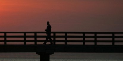Un hombre solitario camina por un muelle