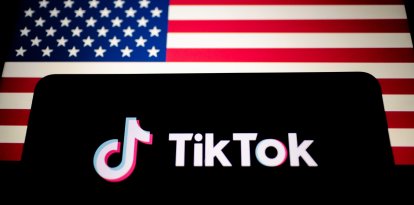 El logotipo de TikTok se muestra en un smartphone junto a la bandera de Estados Unidos. TikTok es una aplicación lanzada en 2016 por ByteDance, una empresa tecnológica china.