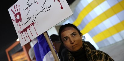Una mujer protesta en solidaridad por la represión en Irán