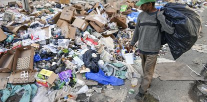 Un hombre camina por una calle de La Habana convertida en basurero