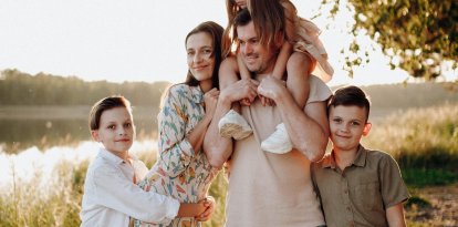 Familia formada por padre, madre y tres hijos, uno de ellos en hombros de su padre