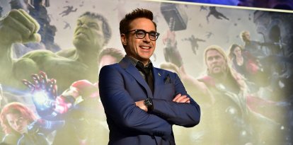 Robert Downey Jr. posa frente a un cartel publicitario de Los Vengadores.