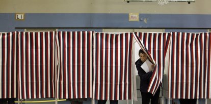 Una votante de New Hampshire sale de una cabina electoral después de rellenar su papeleta para las elecciones de mitad de mandato en el interior del Centro Juvenil Obispo Leo E. Oneil en Manchester, New Hampshire, el 4 de noviembre de 2014.