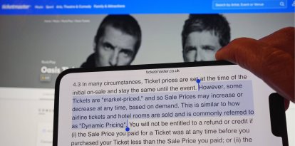 A section of Ticketmaster's purchase policy explaining "Dynamic Pricing" - found on the company's website - is highlighted on a phone, with the Tickemaster website displayed in the background, showing the options for purchasing Oasis tickets, in London. Picture date: Monday September 2, 2024.