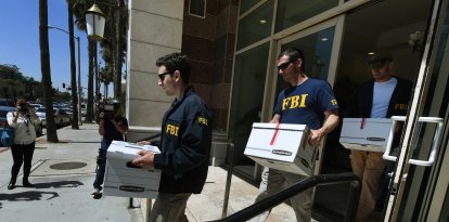 Agentes del FBI retiran cajas de documentos de las oficinas del California Investment Immigration Fund tras presentar órdenes de registro en el marco de una investigación sobre una presunta trama de fraude de visados de alta gama por valor de 50 millones de dólares en la que están implicados hasta 100 ciudadanos chinos en San Gabriel, California, el 5 de abril de 2017.