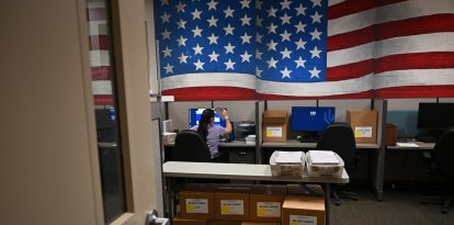 Un trabajador electoral procesa la información de los votantes en la Sala de Banderas del Centro de Tabulación y Elecciones del Condado de Maricopa (MCTEC) antes de las elecciones primarias y generales de Arizona de 2024 en Phoenix, Arizona, el 3 de junio de 2024.