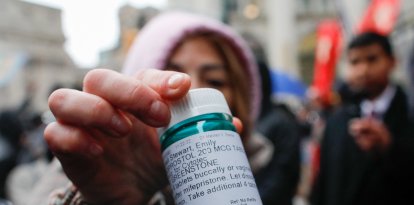 Activistas proaborto con un bote de medicación abortista.