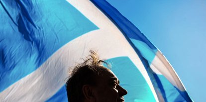 El exministro principal de Escocia Alex Salmond posa con una bandera nacional.