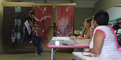 Una mujer sale de una cabina de votación después de emitir su voto durante el referéndum para el estatus político de Puerto Rico en un colegio electoral en Guaynabo, el 11 de junio de 2017.