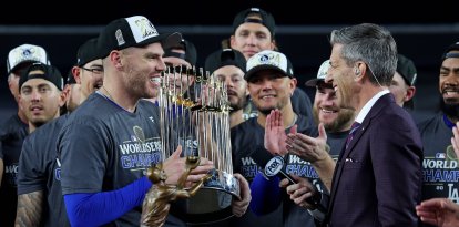 El primera base de los Dodgers de Los Ángeles Freddie Freeman (5) celebra con el Trofeo