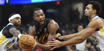 El alero de los Cleveland Cavaliers Evan Mobley (4) regatea entre el escolta de los Golden State Warriors Gary Payton II (0) y el alero Trayce Jackson-Davis (32) en el primer cuarto en el Rocket Mortgage FieldHouse.