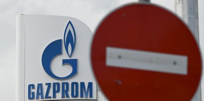 El logotipo del gigante energético ruso Gazprom  junto con una señal de stop.