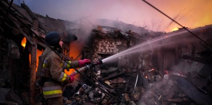 Un rescatista ucraniano trabaja para extinguir un incendio luego de un ataque con drones rusos