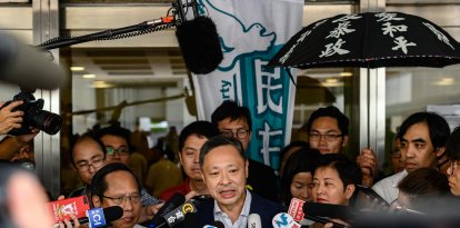 El profesor de derecho de Hong Kong y activista prodemocrático Benny Tai (C)