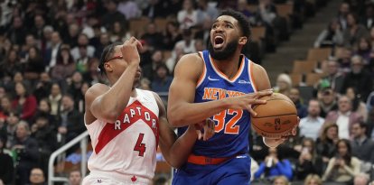 El pívot de los New York Knicks Karl-Anthony Towns (32) conduce contra el alero de los Toronto Raptors Scottie Barnes (4) durante la primera mitad en el Scotiabank Arena.