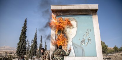 : Un hombre quema una foto del ex presidente sirio Bashar Asad cerca de la frontera de Siria con Líbano