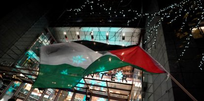 Activists fly a Palestinian flag as they demonstrate during the New York Times DealBook Summit on November 29, 2023. AFP