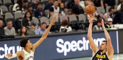 El pívot de los Denver Nuggets Nikola Jokic (15) lanza el balón por encima del pívot de los San Antonio Spurs Victor Wembanyama