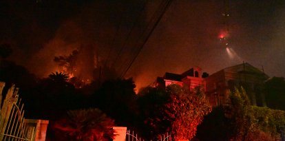 Un agente de policía bajo la maleza en llamas en el incendio de Sunset, cerca de Hollywood Blvd, en Hollywood Hills, Los Ángeles, California, el 8 de enero de 2025.