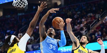 El escolta de los Indiana Pacers Tyrese Haliburton (0) bloquea el tiro del alero de los Cleveland Cavaliers Isaac Okoro (35) mientras el pívot Myles Turner (33) también defiende durante la primera mitad en el Rocket Mortgage FieldHouse.