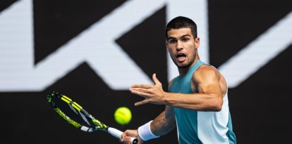 Carlos Alcaraz da un revés de raqueta durante su partido contra Yoshihito Nishioka durante el Open de Australia