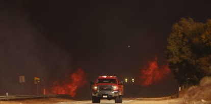 Un camión de bomberos pasa junto al incendio Hughes