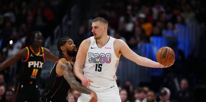 El pívot de los Phoenix Suns Nick Richards (2) defiende al pívot de los Denver Nuggets Nikola Jokic (15) en el primer cuarto en el Ball Arena.