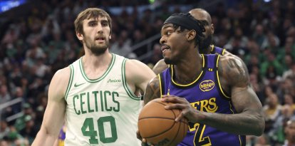 El alero de Los Angeles Lakers Jarred Vanderbilt (2) coge un rebote junto al pívot de Boston Celtics Luke Kornet (40) durante la segunda mitad de un partido de baloncesto de la NBA, el sábado 8 de marzo de 2025, en Boston. (AP Photo/Mark Stockwell)