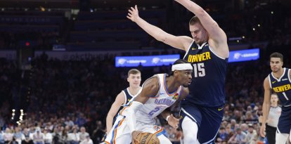 El escolta de los Oklahoma City Thunder Shai Gilgeous-Alexander (2) conduce ante el pívot de los Denver Nuggets Nikola Jokic (15) durante la segunda parte en el Paycom Center.