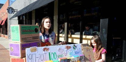 Miembro de las Girl Scouts vendiendo galletas