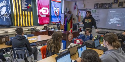 Alumnos asisten a la clase de historia impartida por Jacob Marsh en la Mark Twain Middle School de Alexandria, Virginia, el 6 de marzo de 2025, sin teléfonos inteligentes debido a la prohibición. La prohibición de los teléfonos en la escuela forma parte de una oleada de medidas aplicadas en todo Estados Unidos y de un movimiento mundial que se repite en Brasil, Francia y otros países. Los partidarios creen que las restricciones protegerán a los alumnos de los aparentes perjuicios del uso de teléfonos inteligentes mientras están en la escuela, pero los detractores afirman que las medidas no preparan a los adolescentes para el mundo digital en el que inevitablemente entrarán. (Foto de Jim WATSON / AFP)