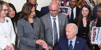 El presidente de EE.UU. Joe Biden (C) entrega el bolígrafo que utilizó para firmar una orden ejecutiva sobre la prevención de la violencia armada a la vicepresidenta de EE.UU. Kamala Harris (L) en la Sala Este de la Casa Blanca en Washington, DC, el 26 de septiembre de 2024.