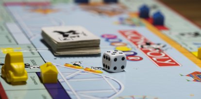 Una familia se divierte jugando Monopoly.