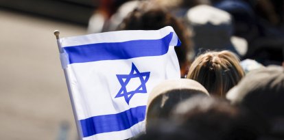 A flag of Israel is seen during a commemoration ceremony at the Bergen-Belsen Memorial in Lohheide, northern Germany on April 27, 2025, on the occasion of the 80th anniversary of the liberation of the Bergen-Belsen concentration camp. The Bergen-Belsen concentration camp was liberated by British forces on April 15, 1945. (Photo by FOCKE STRANGMANN / AFP)