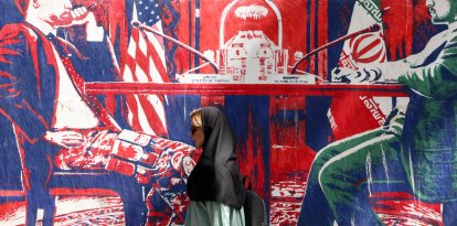 Una mujer pasa junto a un mural cerca de la antigua embajada de EEUU en Teherán