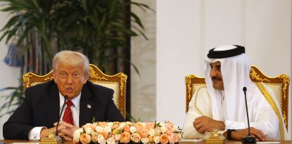El emir de Catar, jeque Tamim bin Hamad al-Thani (d), escucha un discurso del presidente estadounidense, Donald Trump, durante una ceremonia de firma en el Palacio Real de Doha, el 14 de mayo de 2025.