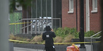 Un forense investiga el lugar del tiroteo frente al Capital Jewish Museum