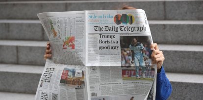 Un lector hojea un ejemplar de The Telegraph