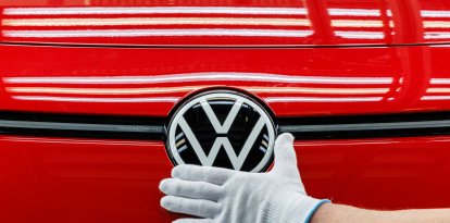Un empleado prepara un coche en la cadena de montaje del Volkswagen