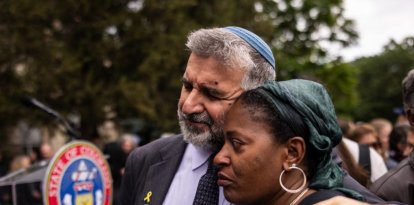 Un rabino consolando a gente en el lugar del ataque contra judíos en Boulder