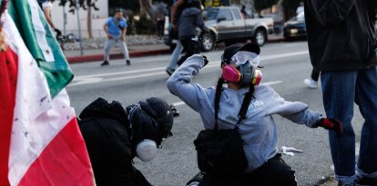 Esta foto tomada el 8 de junio de 2025 muestra a manifestantes lanzando tinta a los agentes de la Patrulla de Carreteras de California durante una manifestación tras las operaciones federales de inmigración en Los Ángeles.